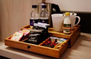 uma caixa de madeira com bebidas e snacks numa mesa em Southgate Hotel London em East Barnet