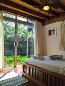 a bedroom with a bed and a large sliding glass door at Tema'e Beach House in Temae