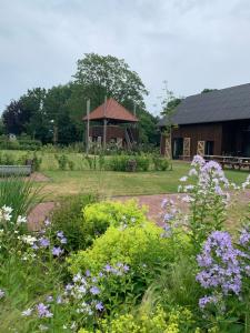 een tuin met bloemen voor een gebouw bij De Hoeven in Veessen