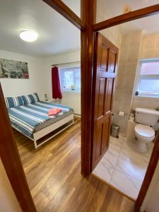1 dormitorio con 1 cama, aseo y puerta en 3 Bedroom House-Garden-Stratford-Olympic Park en Londres