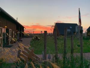 un granero con una puesta de sol en el fondo en De Hoeven, en Veessen
