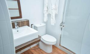 a white bathroom with a toilet and a sink at Holiday Home Kelaa Retreat in Kelaa
