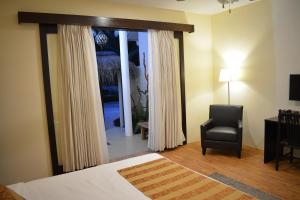 um quarto com uma cama, uma cadeira e uma janela em Holiday Home Kelaa Retreat em Kelaa
