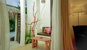 a living room with a chair and a table at Holiday Home Kelaa Retreat in Kelaa