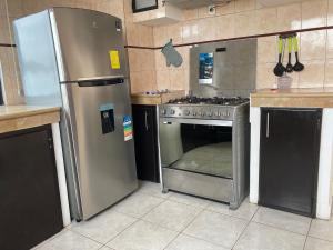 eine Küche mit einem Kühlschrank aus Edelstahl und einem Backofen in der Unterkunft Manta (casa ) in Manta