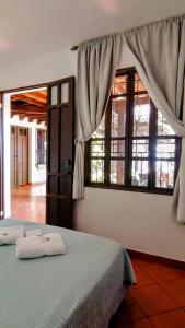 a bedroom with a bed and a window with curtains at Mikaso Hotel in San Pedro La Laguna