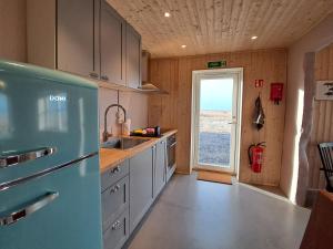 una cucina con frigorifero blu e lavandino di The forgotten farmhouse a Skogar