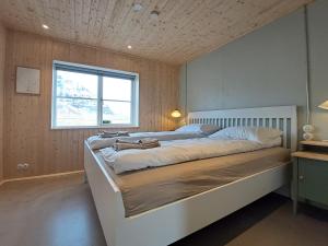 un grande letto in una stanza con finestra di The forgotten farmhouse a Skogar