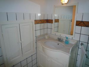 une salle de bain blanche avec un lavabo et un miroir dans l'établissement DANAI HOUSE, à Oia