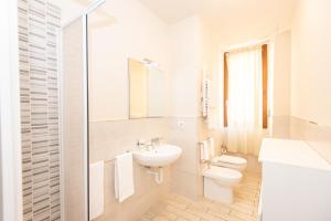 Baño blanco con aseo y lavamanos en Donatello Apartments by Firenze Prestige, en Florencia