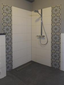 La salle de bains est pourvue d'une douche et de carrelage blanc. dans l'établissement B&B Boerderij La Trappe Deurne, à Deurne