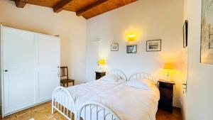 a white bedroom with a bed and a desk at maison de vacances au calme et proche de la plage in La Couarde-sur-Mer