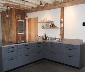 a large kitchen with white cabinets and a sink at B&B Boerderij La Trappe Deurne in Deurne