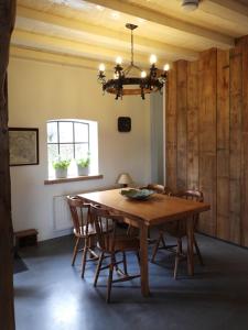 une table à manger avec des chaises et un lustre dans l'établissement B&B Boerderij La Trappe Deurne, à Deurne