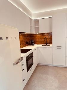 uma cozinha branca com armários brancos e um lavatório em New ! Superbe studio - Déco Marrakech Flair em Mons