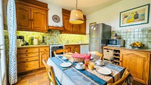 a kitchen with a table with chairs and a refrigerator at maison de vacances au calme et proche de la plage in La Couarde-sur-Mer +5 photos