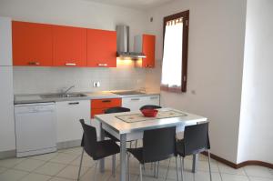 cocina con armarios rojos, mesa y sillas en Isola, en Marina di Castagneto Carducci