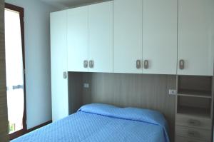 1 dormitorio con 1 cama azul y armarios blancos en Isola, en Marina di Castagneto Carducci