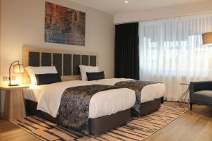 a hotel room with two beds and a window at The Capri Hotel Osmanbey in Istanbul