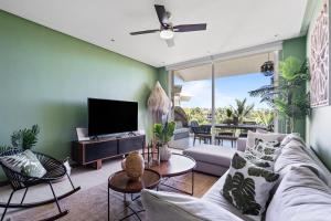een woonkamer met een bank en een tv bij Stylish Peninsula Golf 3BR Oasis with Pool in Nuevo Vallarta 