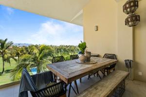 ヌエボ・バジャルタにあるStylish Peninsula Golf 3BR Oasis with Poolの木製のテーブルと椅子のあるダイニングルーム