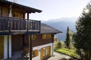a house with a balcony on the side of it at Chalet La Madelon idéal pour les grandes familles in Hérémence