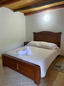 1 dormitorio con 1 cama con cabecero de madera en CASA VACACIONAL SAN MARCOS, en Villa de Leyva