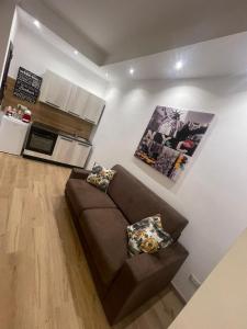 a living room with a brown couch and a kitchen at Relax Apartment 39 in Crotone +7 photos