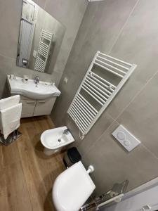 La salle de bains est pourvue de toilettes blanches et d'un lavabo. dans l'établissement Relax Apartment 39, à Crotone