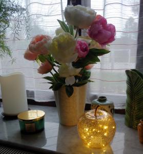 un jarrón de flores sobre una mesa con una vela en Ferienwohnung am Garten, en Weißenberg