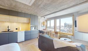 a living room with a couch and a kitchen at Hébergement Mont-Ste-Anne Condos in Beaupré