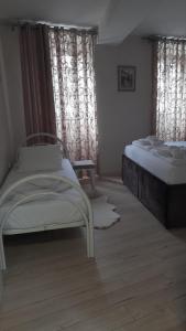 a bedroom with two beds and a window with curtains at Nada's room with terrace in Kotor