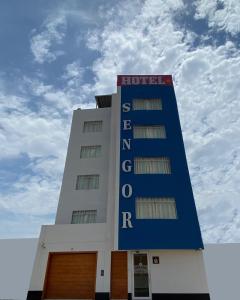 un bâtiment d'hôtel avec un panneau en haut dans l'établissement Hotel Sengor, à Urbanizacion Buenos Aires