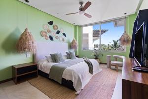 ヌエボ・バジャルタにあるStylish Peninsula Golf 3BR Oasis with Poolのベッドと薄型テレビのある寝室 +45枚の写真