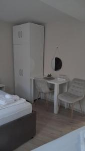 a bedroom with a desk and a table and a chair at Nada's room with terrace in Kotor