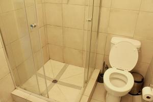 a bathroom with a shower with a toilet at Exquisite 1-Bed Apartment in Sandton in Johannesburg