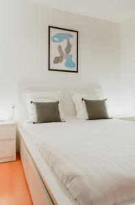 une chambre blanche avec un grand lit blanc dans l'établissement Paillette, au Havre