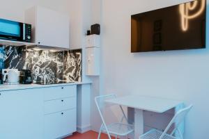 une cuisine avec un bureau et une télévision au mur dans l'établissement Paillette, au Havre 8 autres photos