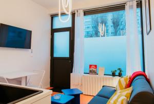 un salon avec un canapé et une fenêtre dans l'établissement Paillette, au Havre