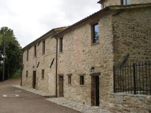 een oud bakstenen gebouw met een zwarte poort bij La Collina Con Gli Ulivi in Perugia