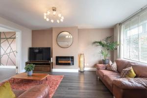 a living room with a couch and a fireplace at Stunning 3 Bed Home in Gloucester in Down Hatherley