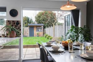 uma sala de jantar com uma mesa e um relógio em Stunning 3 Bed Home in Gloucester em Down Hatherley