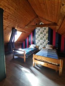 twee bedden in een kamer met een houten plafond bij gîte des 2 Lions in Murs-et-Gélignieux