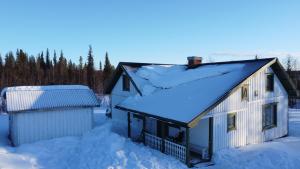 una casa con nieve en el techo en Arctic Cottage Kiruna, Groups en Kiruna