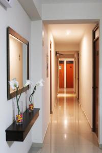 a hallway with a mirror and flowers on a wall at Hotel Sengor in Urbanizacion Buenos Aires