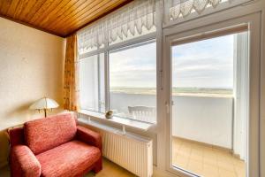 sala de estar con silla y ventana grande en Ferienpark - Haus E, App 0E1108, en Heiligenhafen