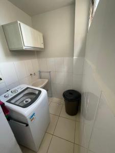 a small bathroom with a toilet and a washer at Apt. Aconchegante in Araguari