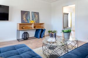 ein Wohnzimmer mit einem blauen Sofa und einem Tisch in der Unterkunft Inge-Marie in Westerland