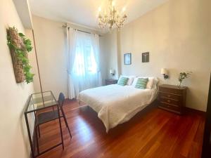 um quarto com uma cama, uma mesa e uma janela em Casa PilarCasco Viejo Wifi em Bilbao