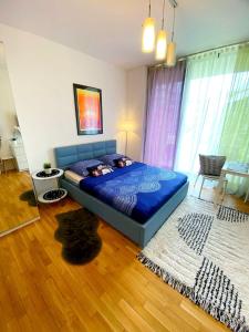a bedroom with a blue bed in a room at HomeComfort Apartament Gulia in Warsaw
